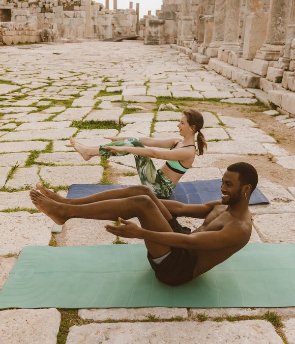Diverse group of people smiling during a yoga session outdoors.